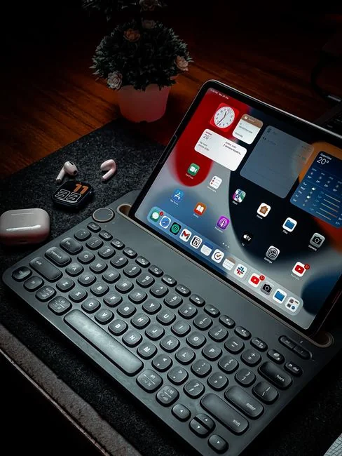 A tablet with a financial website open, alongside a white keyboard and mouse. Ideal for tech-theme stock images.