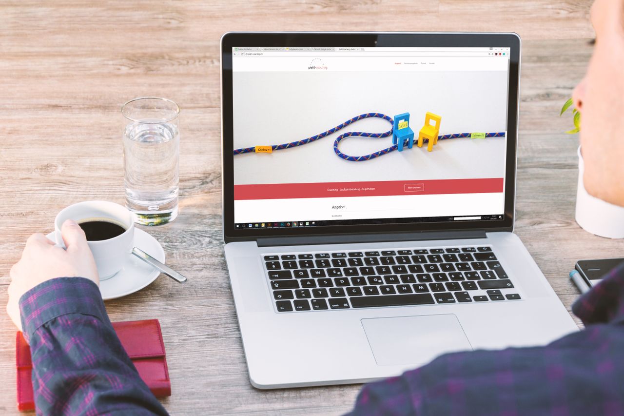 Bureau professionnel avec ordinateur portable, café et verre d’eau, illustrant la technologie moderne et la productivité.
